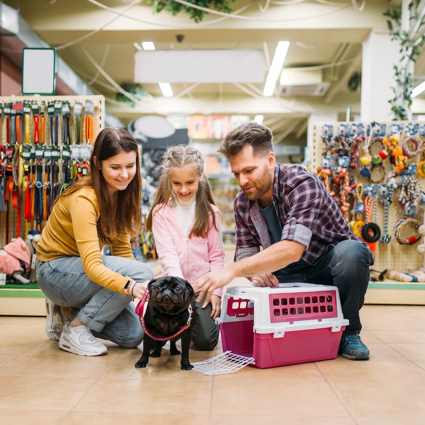 Family buying supplies for little puppy in petshop Family buying supplies for little puppy in petshop. Father, mother and dauther chooses accessories for dog in pet shop